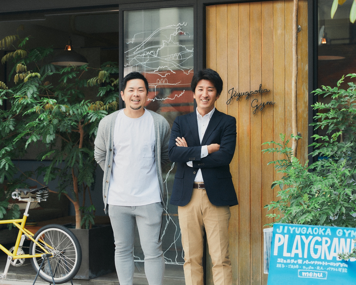 店舗の前で笑顔を見せる二人